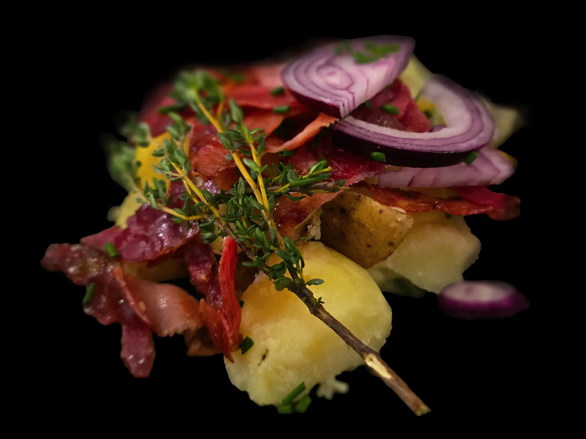 Gnocchis avec pommes de terre, lard grillé, oignon rouge et herbes fraîches